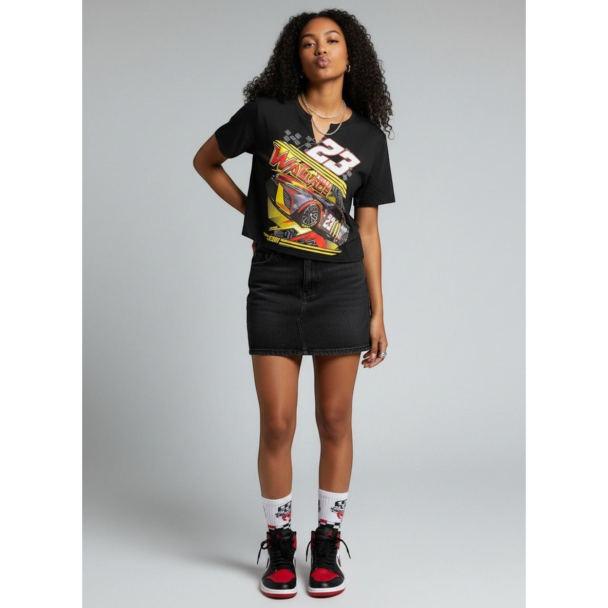 Sweet Plus Savage black cotton t-shirt with a racecar graphic and number 23 on the front. Model wears a black denim skirt.
